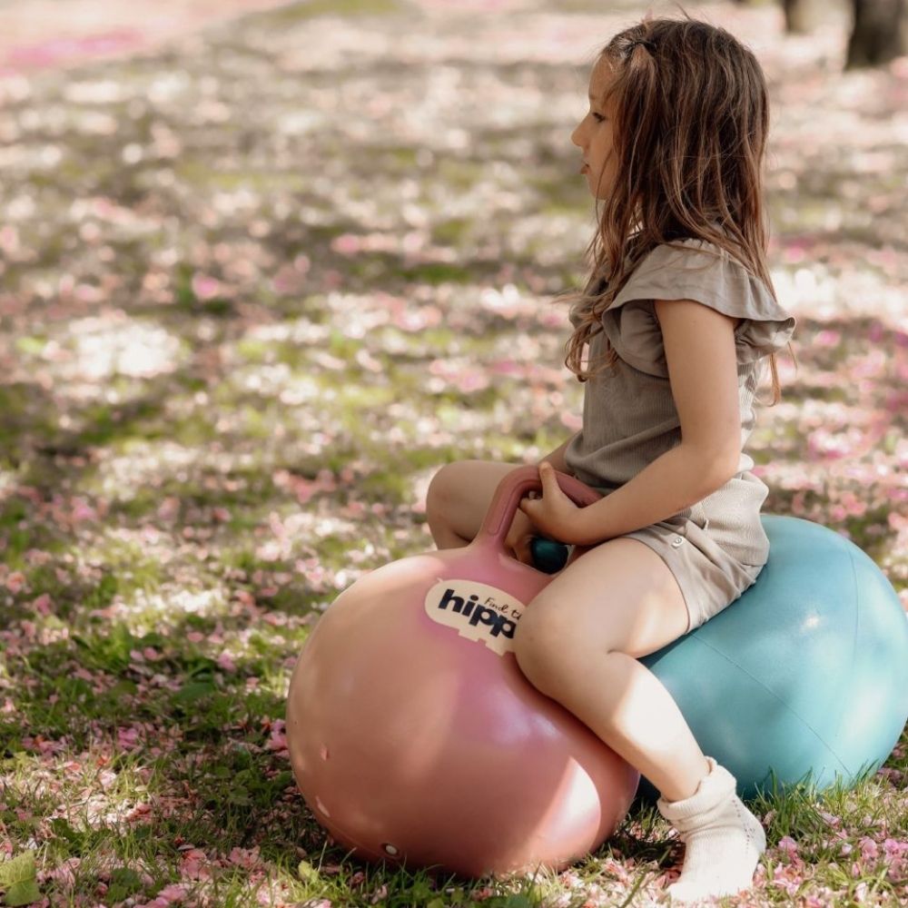 Barn leger i en park på rosa og blå hoppebold fra Find that Hippo til sjov, aktiv leg og motorisk træning, fås hos Nordic Simply