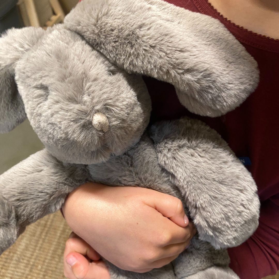 Barn holder grå kaninbamse med blød øko-tex® certificeret pels og lange ører fra Moulin Roty, godkendt fra 0 år, fås hos Nordic Simply