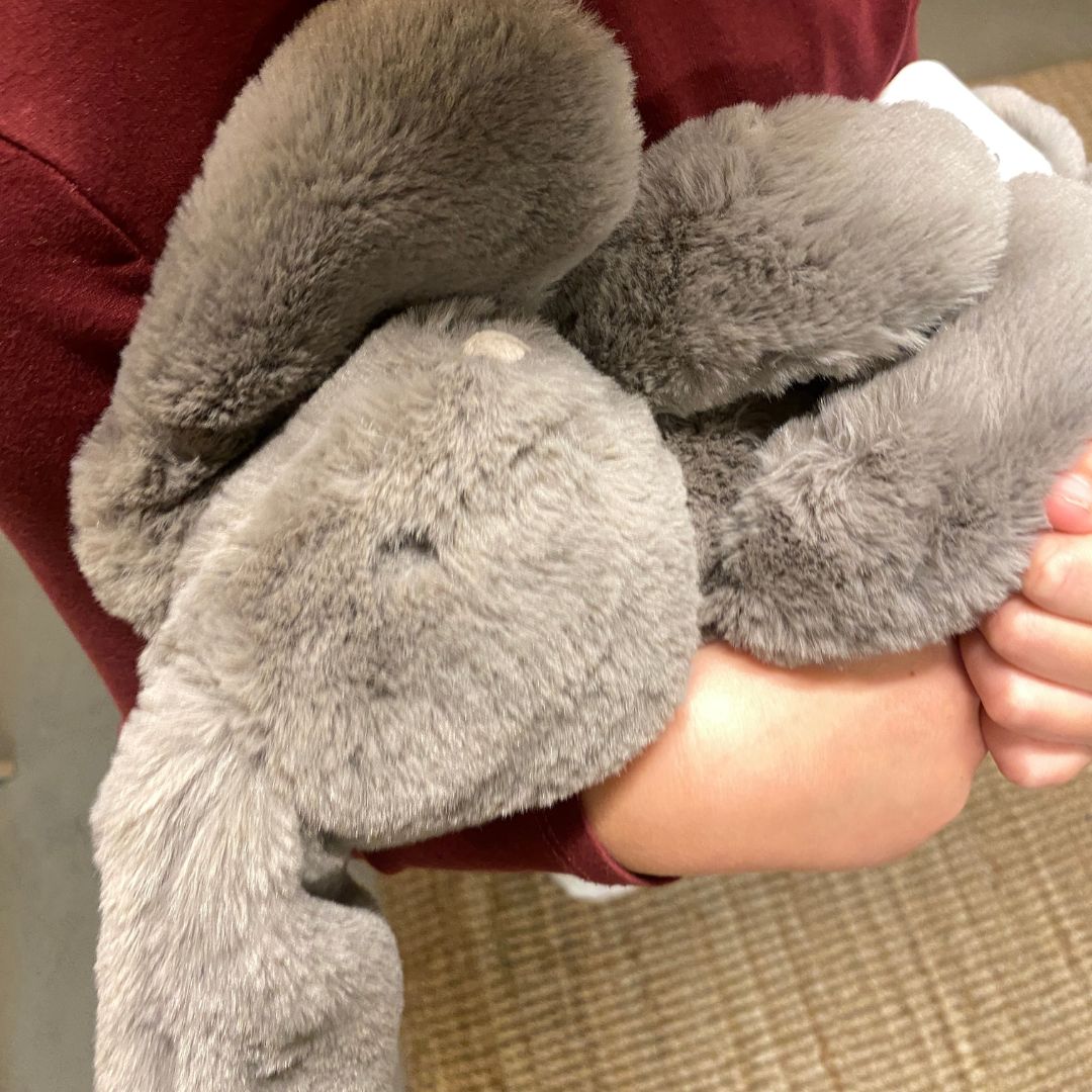 Barn med grå kaninbamse med blød pels og lange ører fra Moulin Roty, godkendt fra 0 år. Perfekt som barselsgave fås hos Nordic Simply