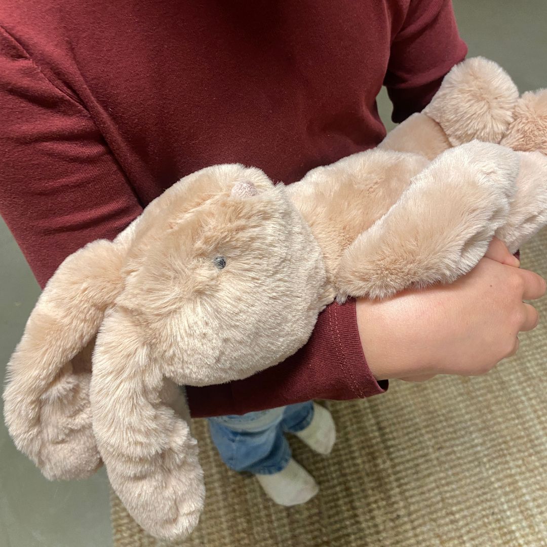 Barn holder rosa kaninbamse med blød øko-tex® certificeret pels og lange ører fra Moulin Roty, godkendt fra 0 år. Perfekt som barselsgave fås hos Nordic Simply