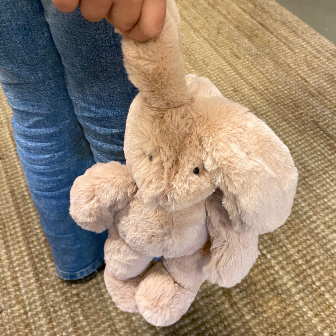 Barn holder rosa kaninbamse i dens lange øre. Plyskanin med blød øko-tex® certificeret pels fra Moulin Roty, godkendt fra 0 år. Perfekt som barselsgave fås hos Nordic Simply