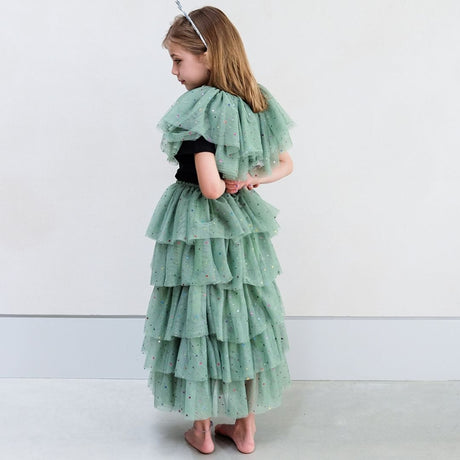 Pige set bagfra med langt grønt skørt i tyl og kort grøn kappe i tyl med flere lag, bindebånd med guldstjerner og masser af små stjerner i stoffet, perfekt til udklædning, fra Mimi & Lula fås hos Nordic Simply