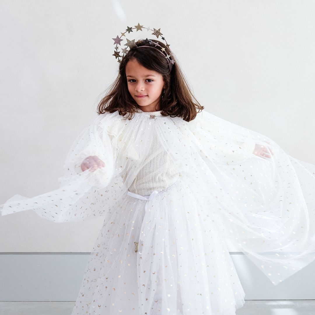 Pige snurrer rundt med lang hvid kappe og tylskort med masser af små guld stjerner, perfekt til udklædning som fe, lucia og prinsesse, fra Mimi & Lula fås hos Nordic Simply