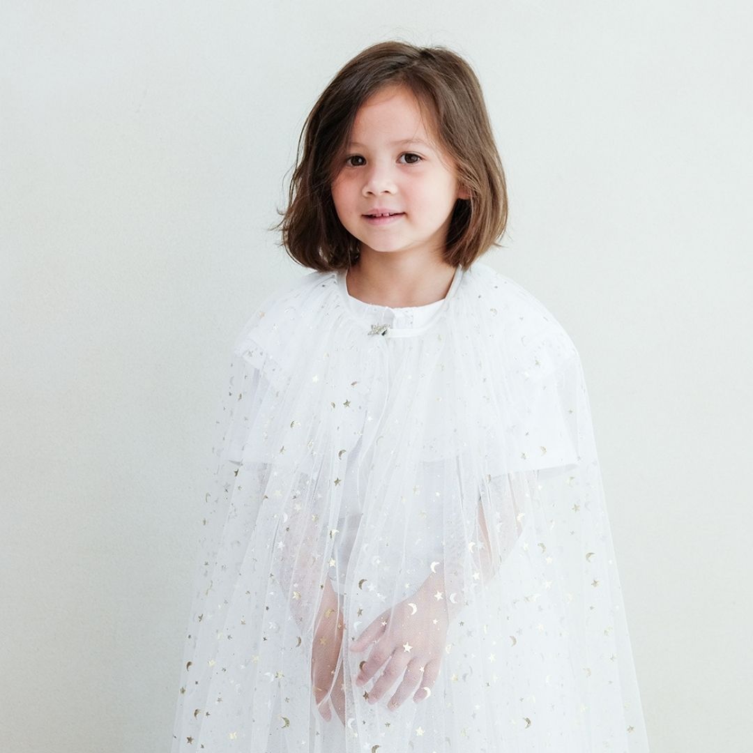 Pige med lang hvid kappe i tyl med masser af små guld stjerner, smuk udklædning fra Mimi & Lula fås hos Nordic Simply