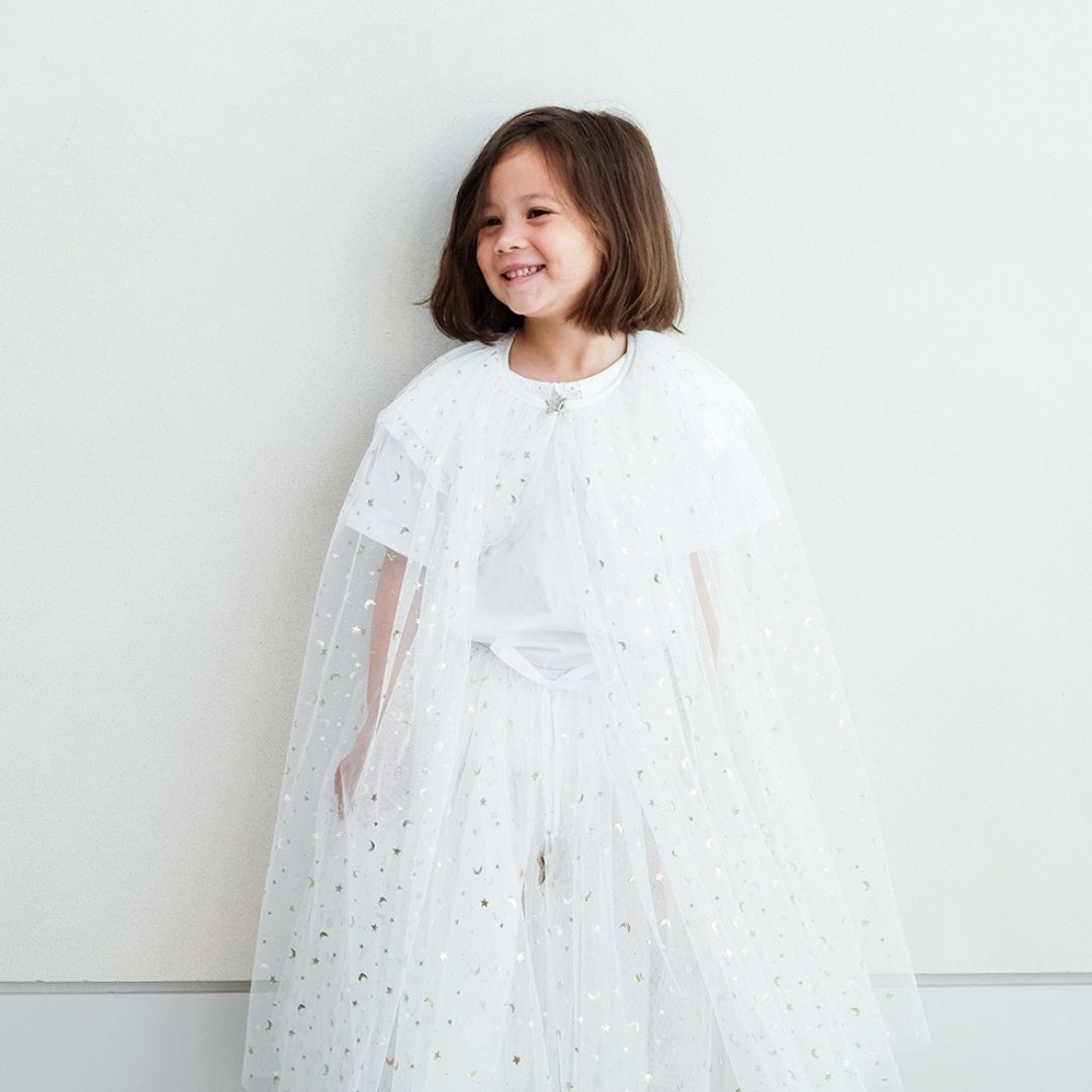 Pige med lang hvid kappe og tylskort med masser af små guld stjerner, perfekt til udklædning som fe, lucia og prinsesse, fra Mimi & Lula fås hos Nordic Simply