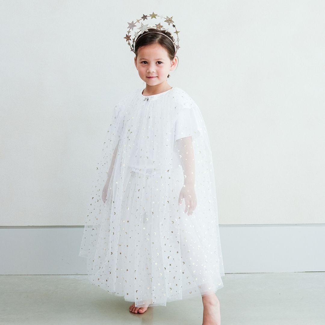 Pige med glorie hårbøjle samt lang hvid kappe og tylskort med masser af guld stjerner, perfekt til udklædning som fe, lucia og prinsesse, fra Mimi & Lula fås hos Nordic Simply