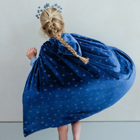 Barn i lang blå velour kappe med hætte, dækket af stjerner og svinger rundt som en prinsesse.