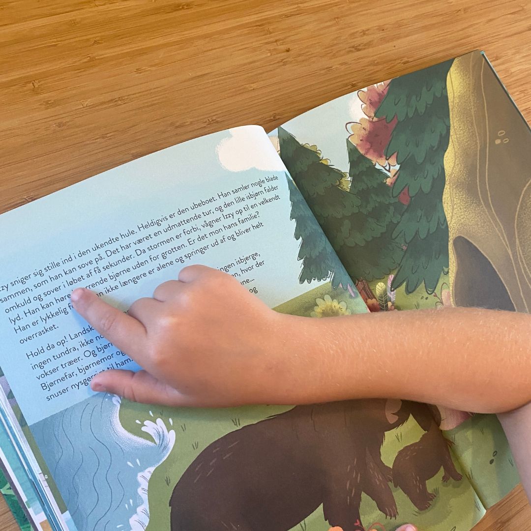 Hånd peger på linjer i klimabog til børn Sådan Passer vi på Jorden, fås hos Nordic Simply