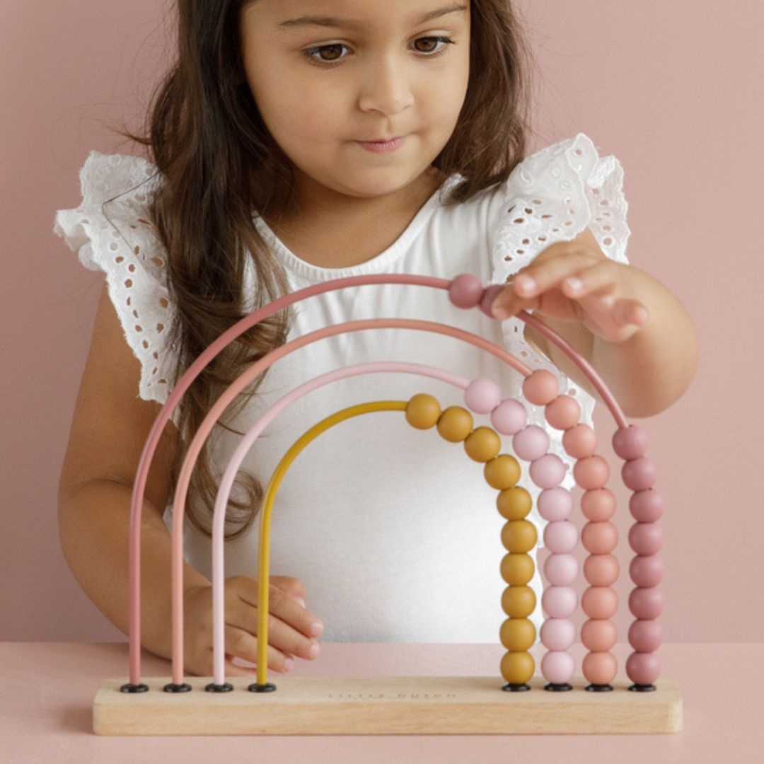 Pige leger med smuk regnbue kugleramme i rosa fra Little Dutch, fås hos Nordic Simply