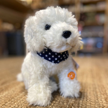 hvid labradoodle bamse sidder på tæppe hos Nordic Simply