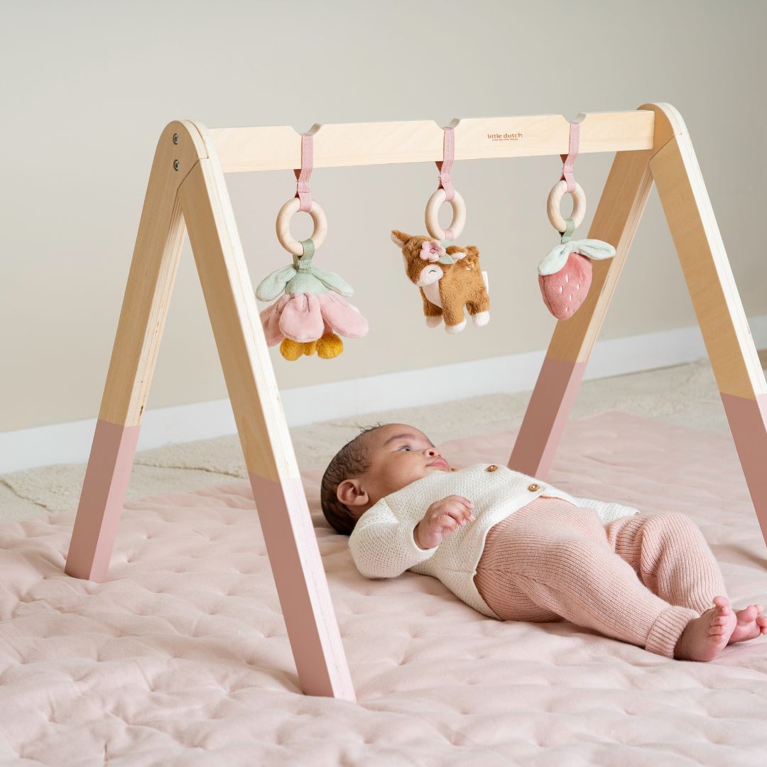 Baby pige på rosa legetæppe under aktivitetsstativ fra Little Dutch, fås hos Nordic Simply.