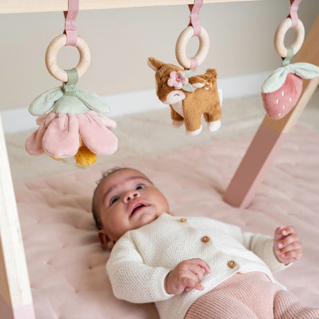 Baby der ligger på rosa legetæppe under aktivitetsstativ fra Little Dutch, fås hos Nordic Simply.
