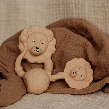 Biderangle og rangle i naturgummi med løve fra Natruba hos Nordic Simply, placeret på en brun stofble