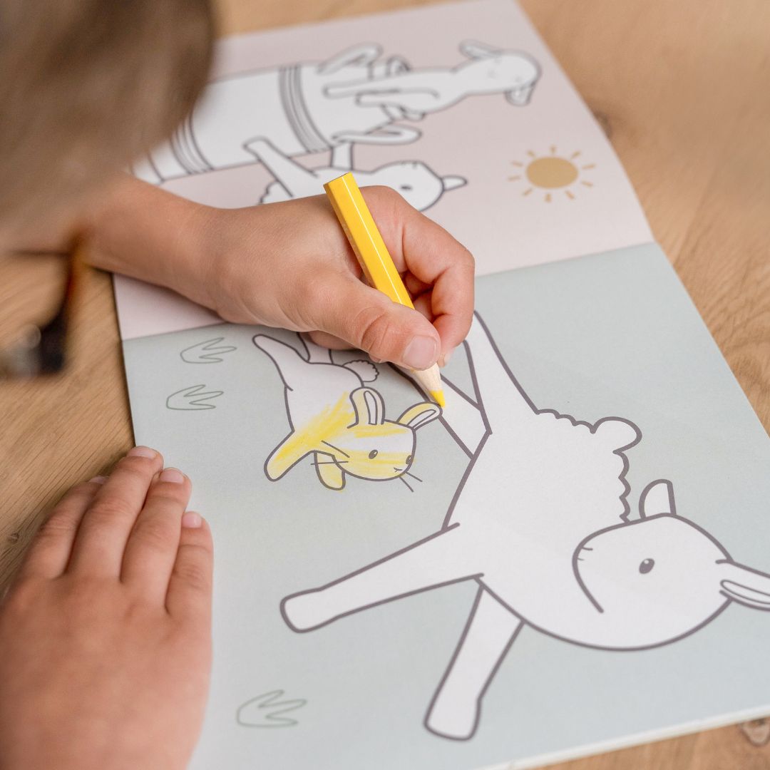 Barn tegner et får i malebog med motiver af bondegården fra Little Dutch. God fra 2 år og op