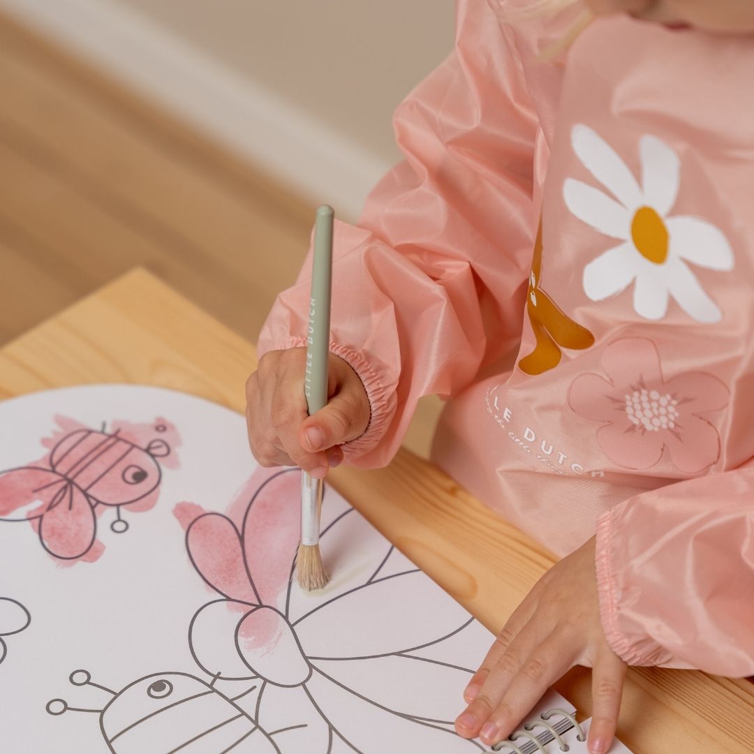 Barn maler blomst rosa med pensel i malebog, fra Little Dutch, fås hos Nordic Simply