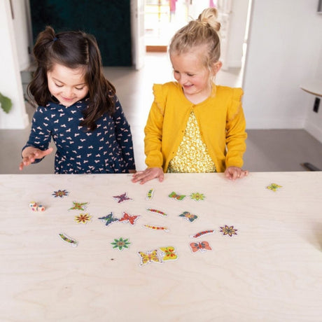 To piger sidder ved bord og spiller minispil "fang en sommerfugl" fra Scratch fås hos Nordic Simply