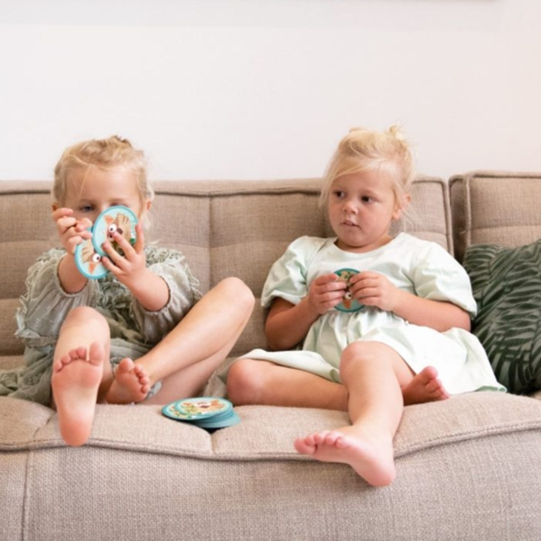 To piger i sofa med brikker fra vendespil med vaskebjørne mini rejsespil til børn fra Scratch fås hos Nordic Simply