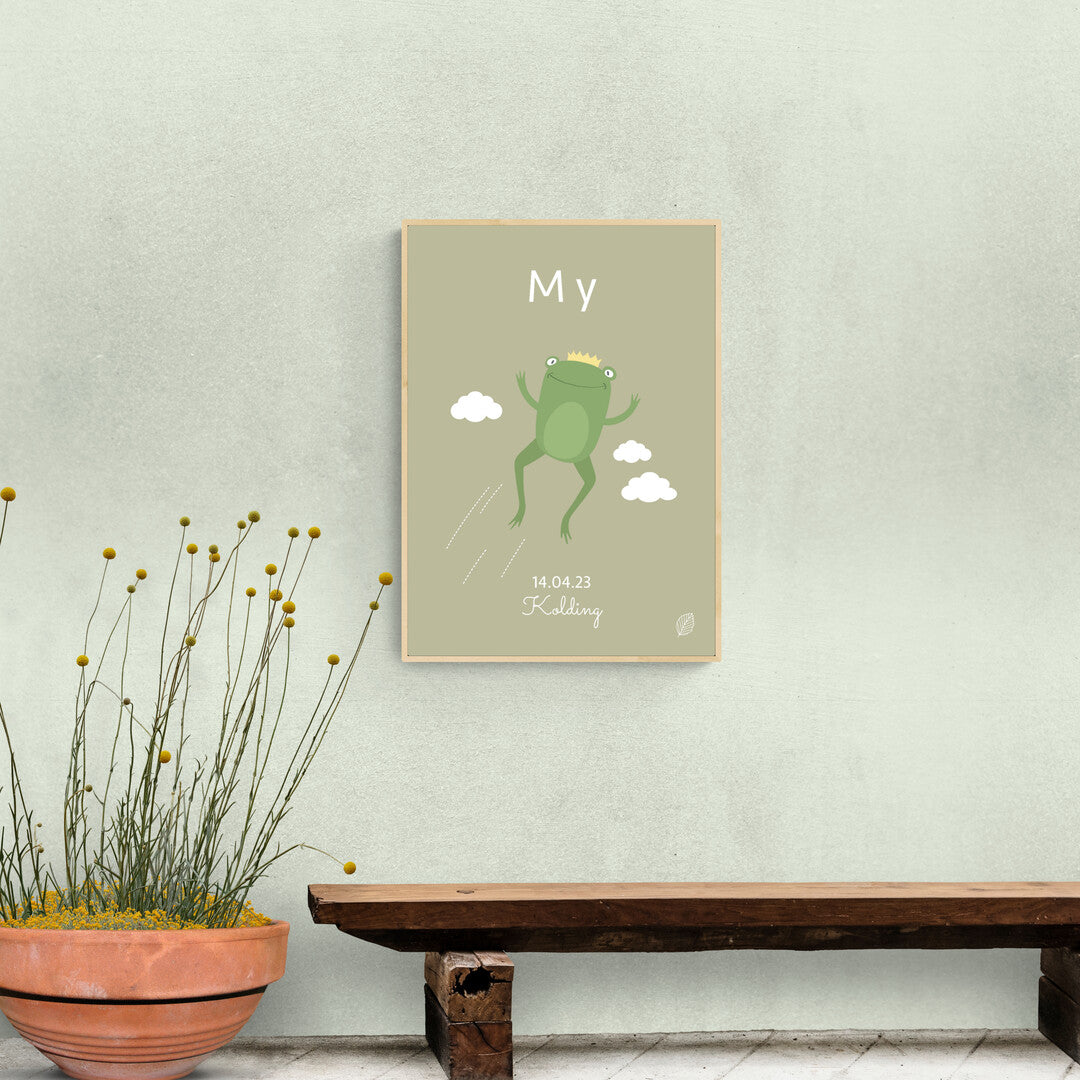 Olivenfarvet plakat med illustration af frø der springer, personlig plakat til barn med navn, fødselsdato og by, set i entre over  gammel bænk i træ, fra Nordic Simply