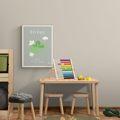 Grøn plakat med illustration af kålorm, personlig plakat til barn med navn, fødselsdato og by, set i træramme på børneværelse, fra Nordic Simply