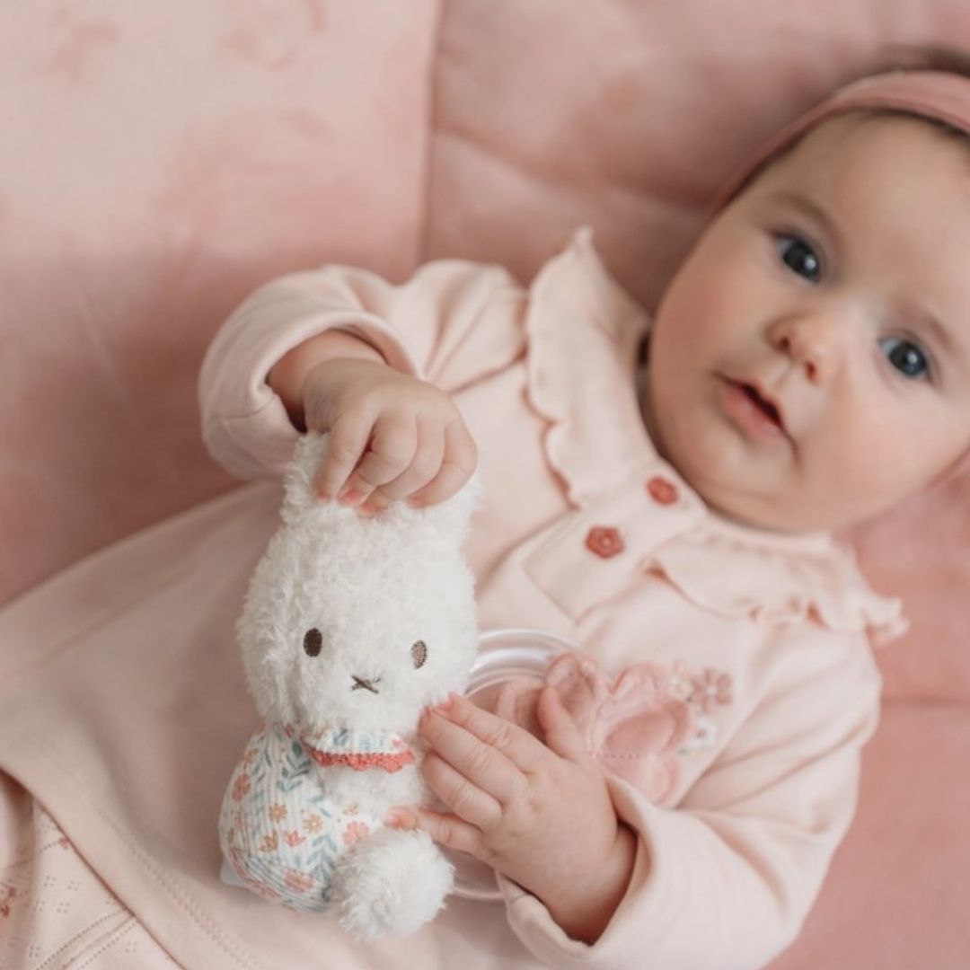 Rangle til baby | Kanin rosa - Sødt billede af baby, der leger med en Miffy kanin rangle.