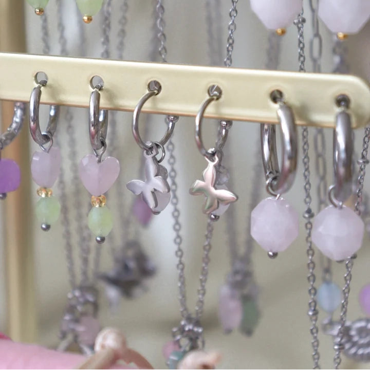 Øreringe i sølv med facetslebet rosenkvarts vedhæng. Statement hoops, du kan mikse og matche med andre øreringe og smykker. Her set sammen med andre ørering på display.