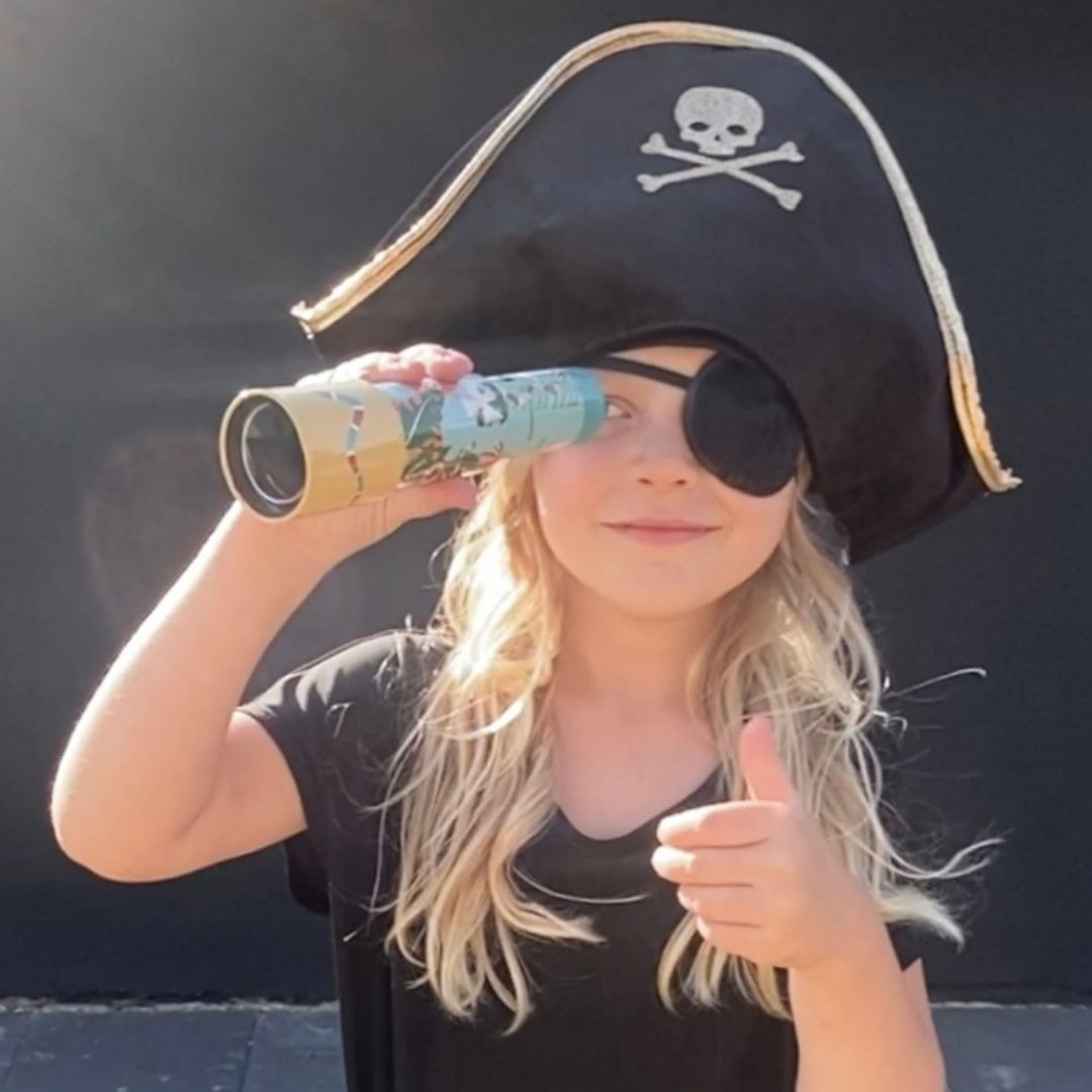 Pige ser i kikkert og leger sørøver med sort pirathat og sort klap for øjet, fra Mimi & Lula fås hos Nordic Simply