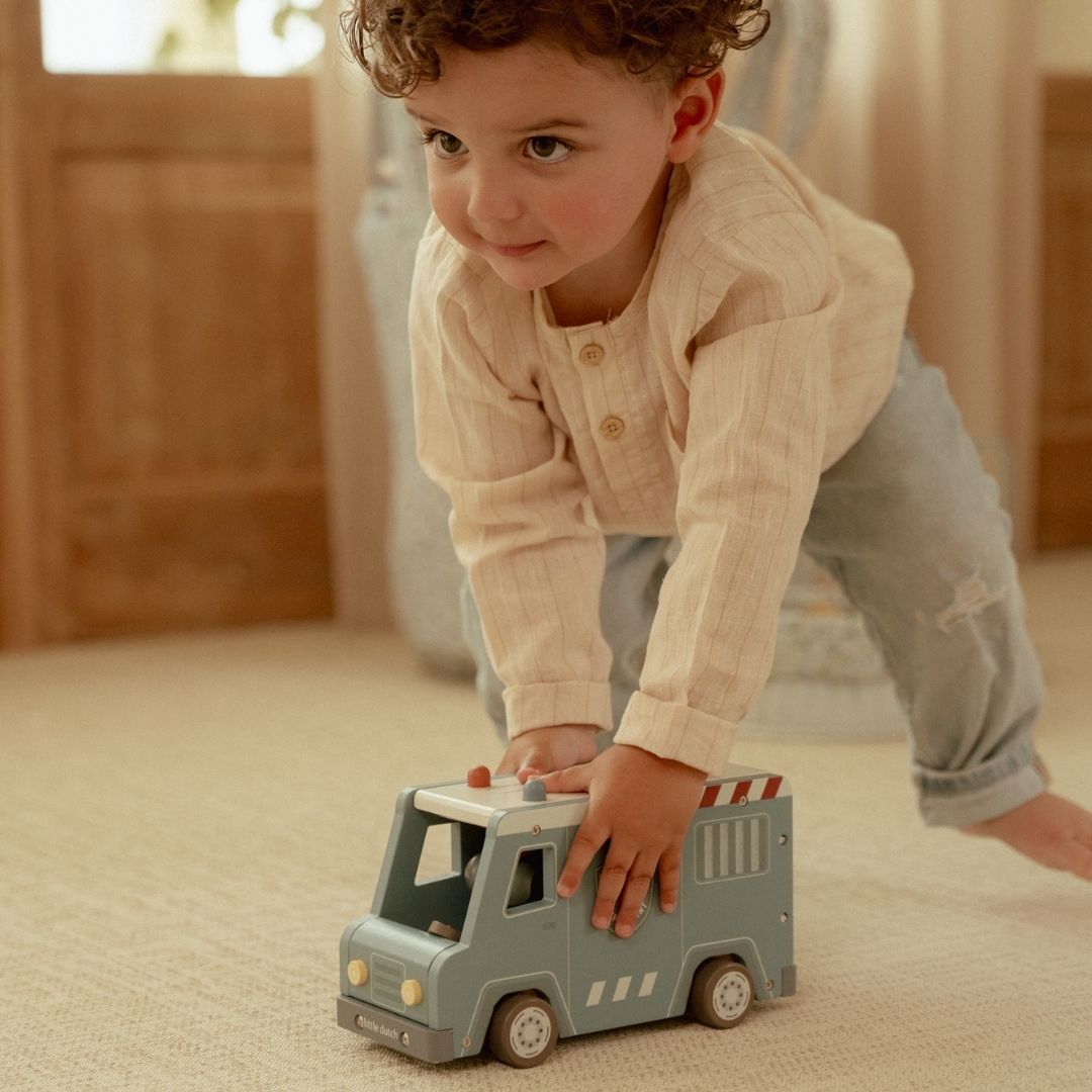 Politibil med træfigurer og hund: Barn leger med den blå træ politibil med blinklys.