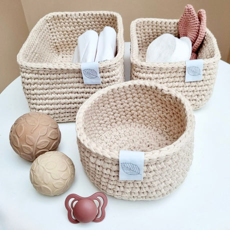 Puslekurvesæt til puslepladsen med 3 håndlavede kurve i lys sand , set med sansebolde, sut og andre produkter til baby, puslekurve fås hos Nordic Simply