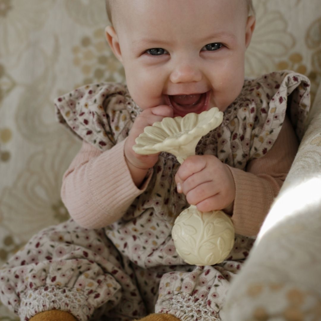 Baby holder gul rangle og bidering i et, formet som en marguerit, med teksturer til baby, lavet i naturgummi af Natruba, fås hos Nordic Simply