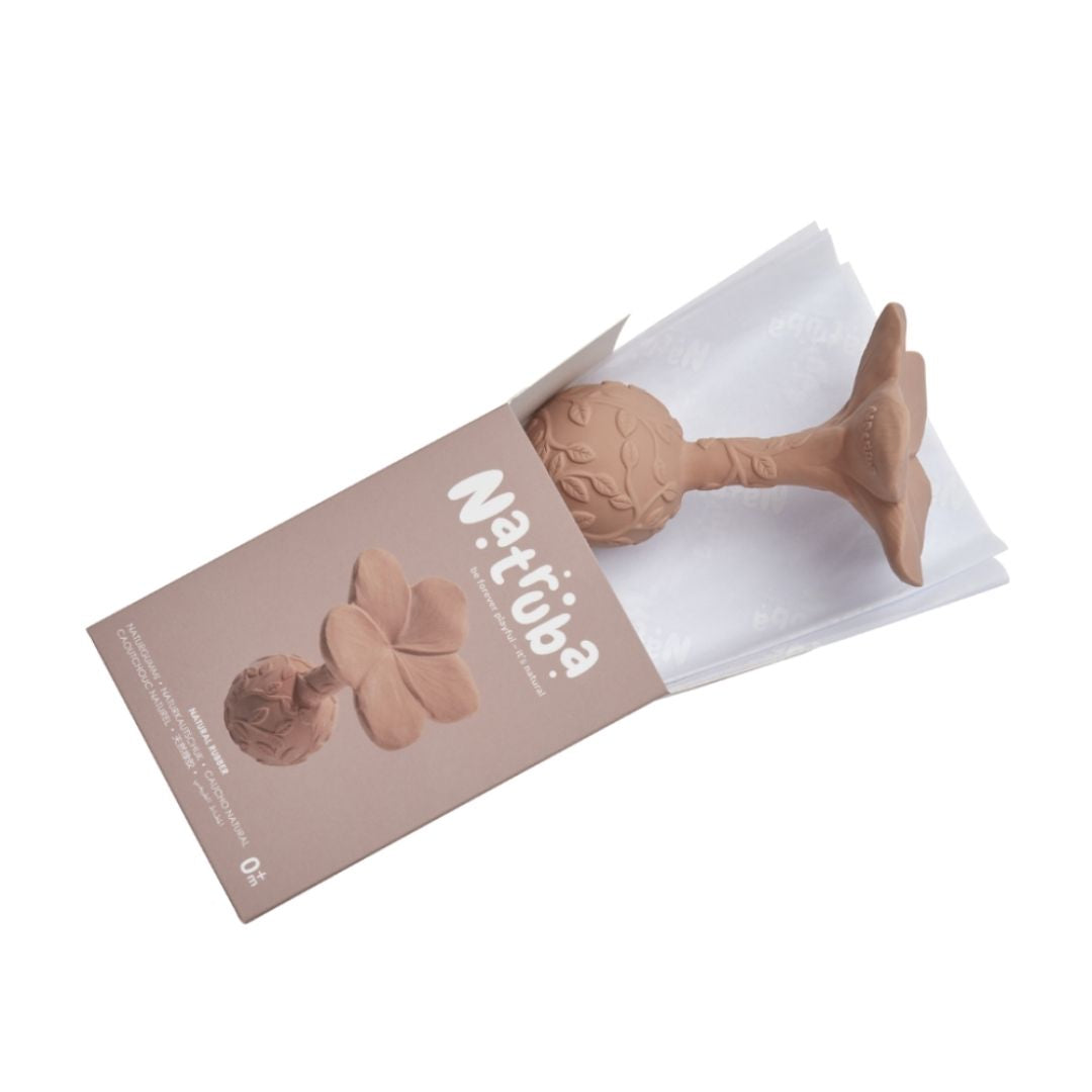 Rosa rangle, formet som en plumeria med teksturer til baby, lavet i naturgummi af Natruba, set på vej ud af æske på hvid baggrund.