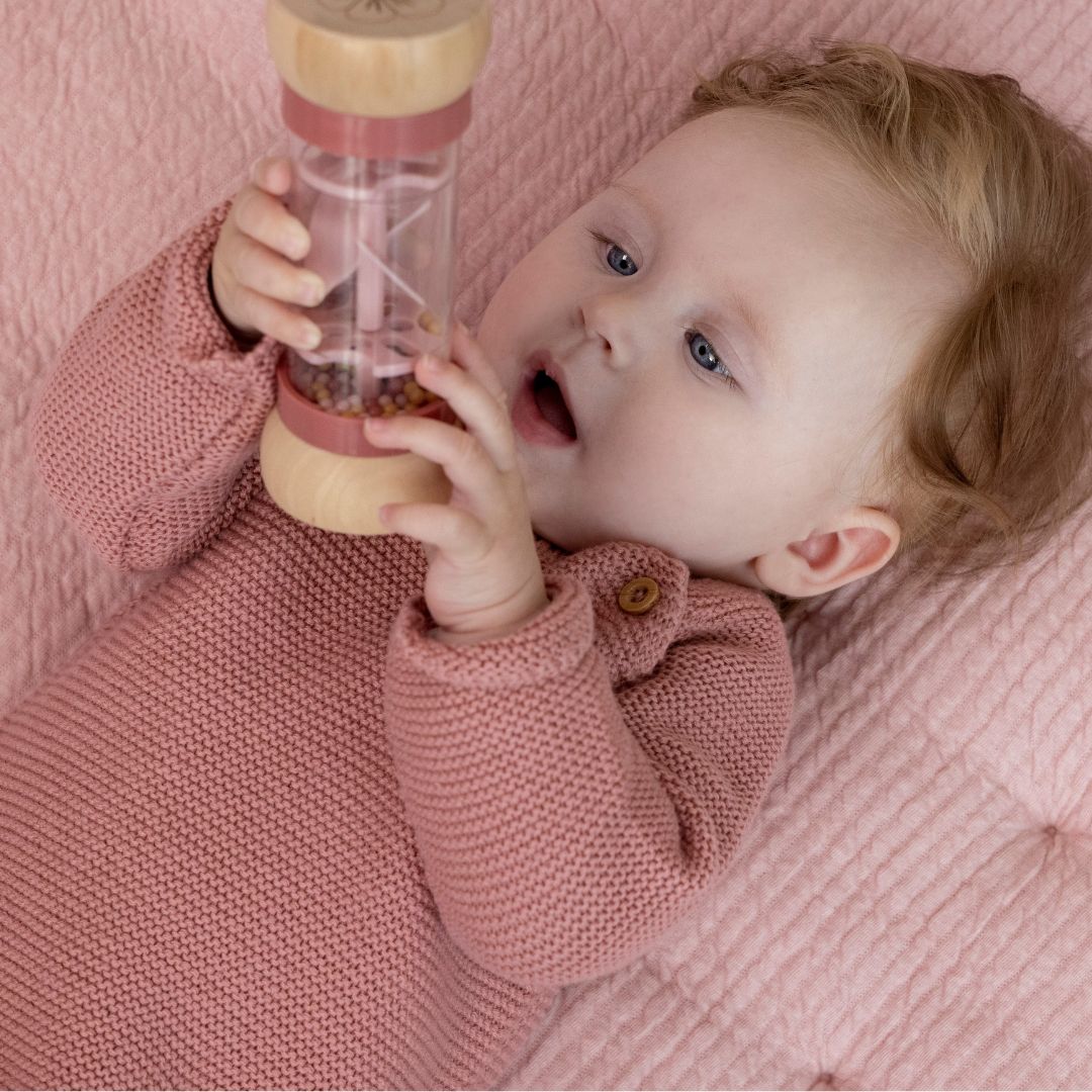 baby pige undersøger rosa regnmager fra Little Dutch, fås hos Nordic Simply