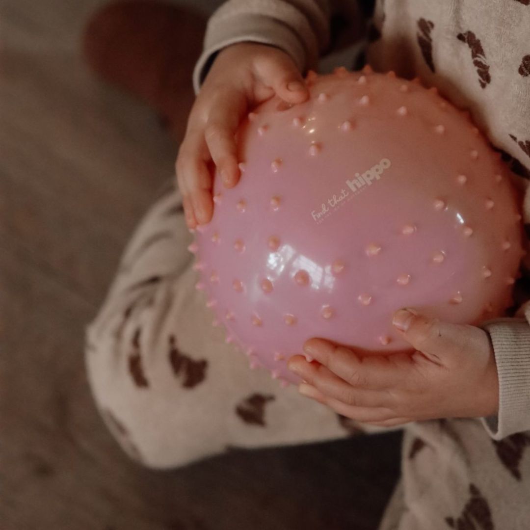 barnehænder holder rosa sansebold fra Find that Hippo