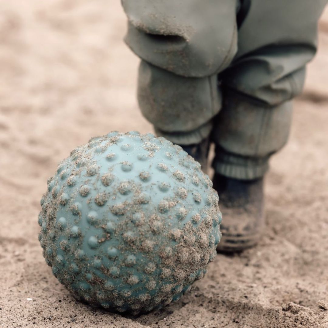 Stor blå sansebold med knopper i sand, perfekt til sansestimulation og motorisk leg for børn.
