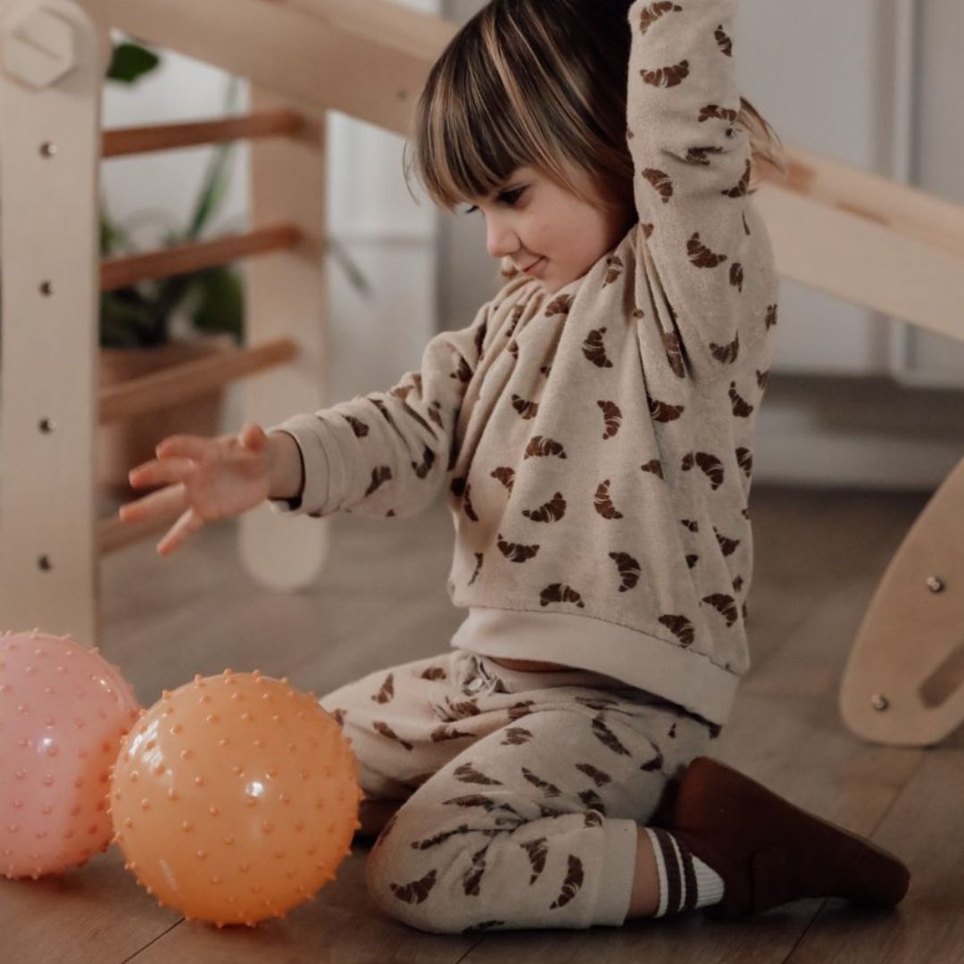 barn sidder i stue og leger med to store sansebolde i gul og rosa fra Find that Hippo