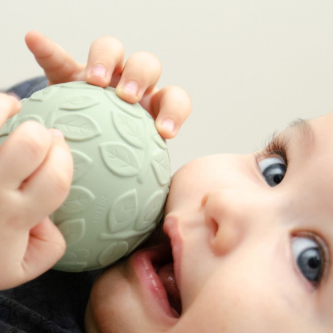 Baby holder grøn sansebold i naturgummi med teksturer, fra Natruba, fås hos Nordic Simply
