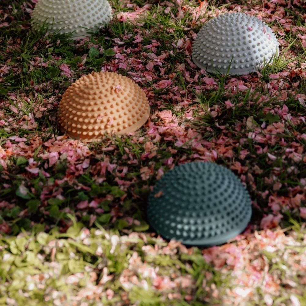 4 sansesten med knopper i mørke pastelfarver ligger udendørs i skovbund, fås hos Nordic Simply