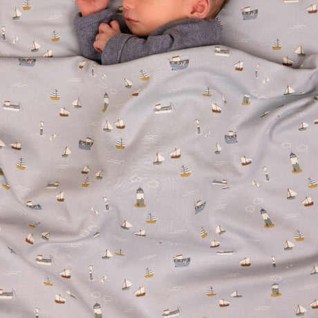 baby sover i lyseblå sengesæt med små skibe fra Little Dutch fås hos Nordic Simply