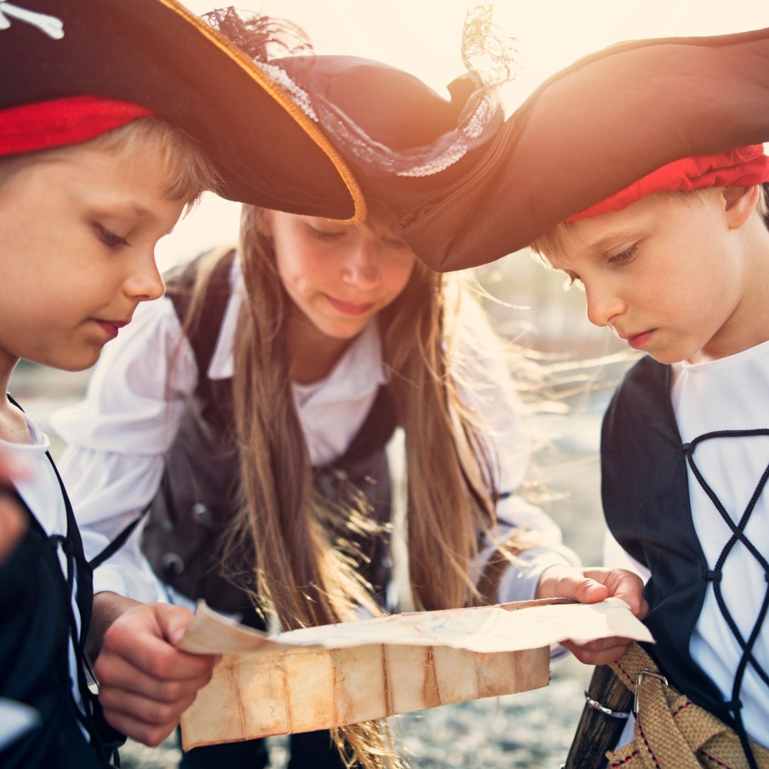 Børn til børnefødselsdag klædt ud som pirater holder skattekort, klar til pirat-skattejagt fra Nordic Simply