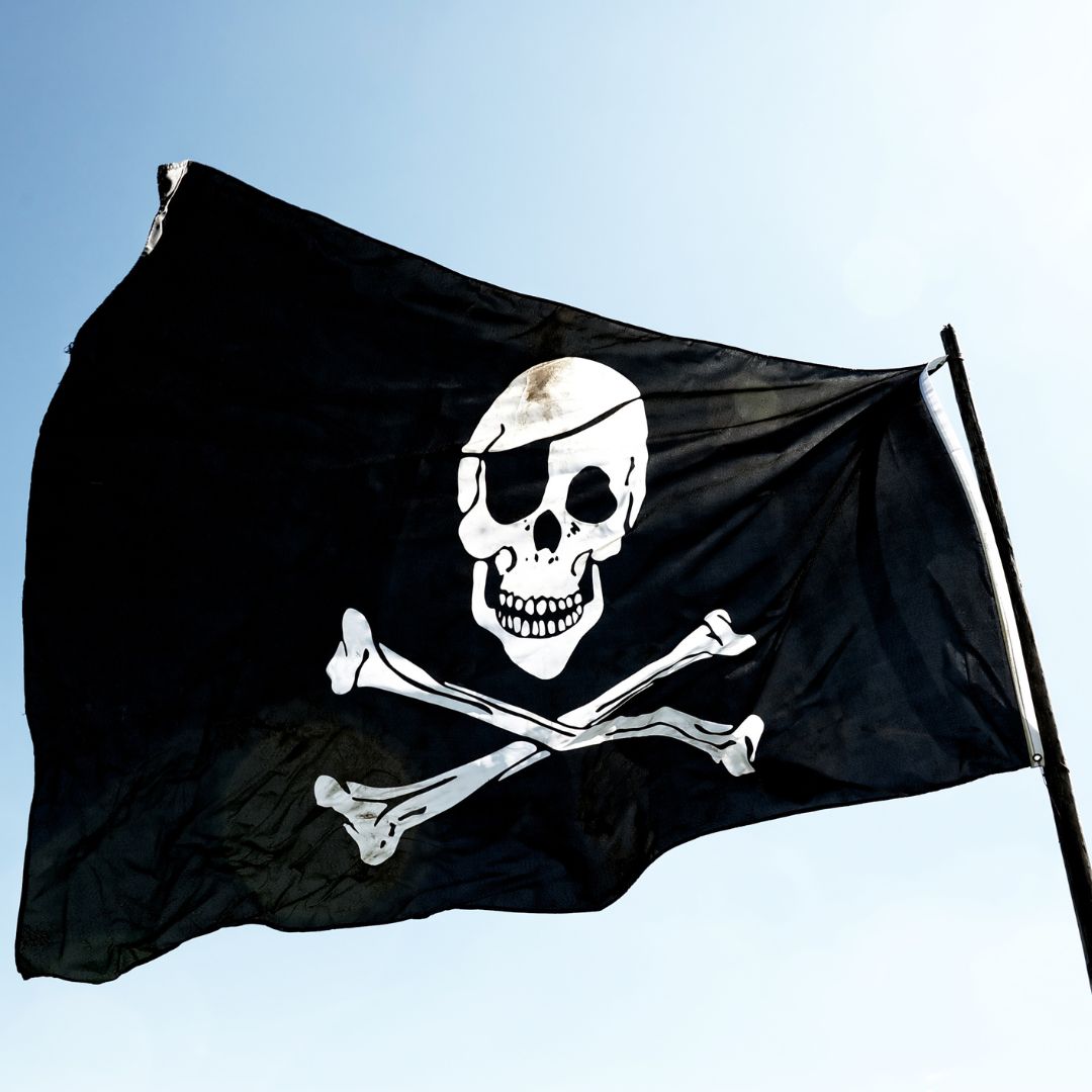 Sørøverflag set på blå himmel, pynt til børnefødselsdag med pirat-tema.