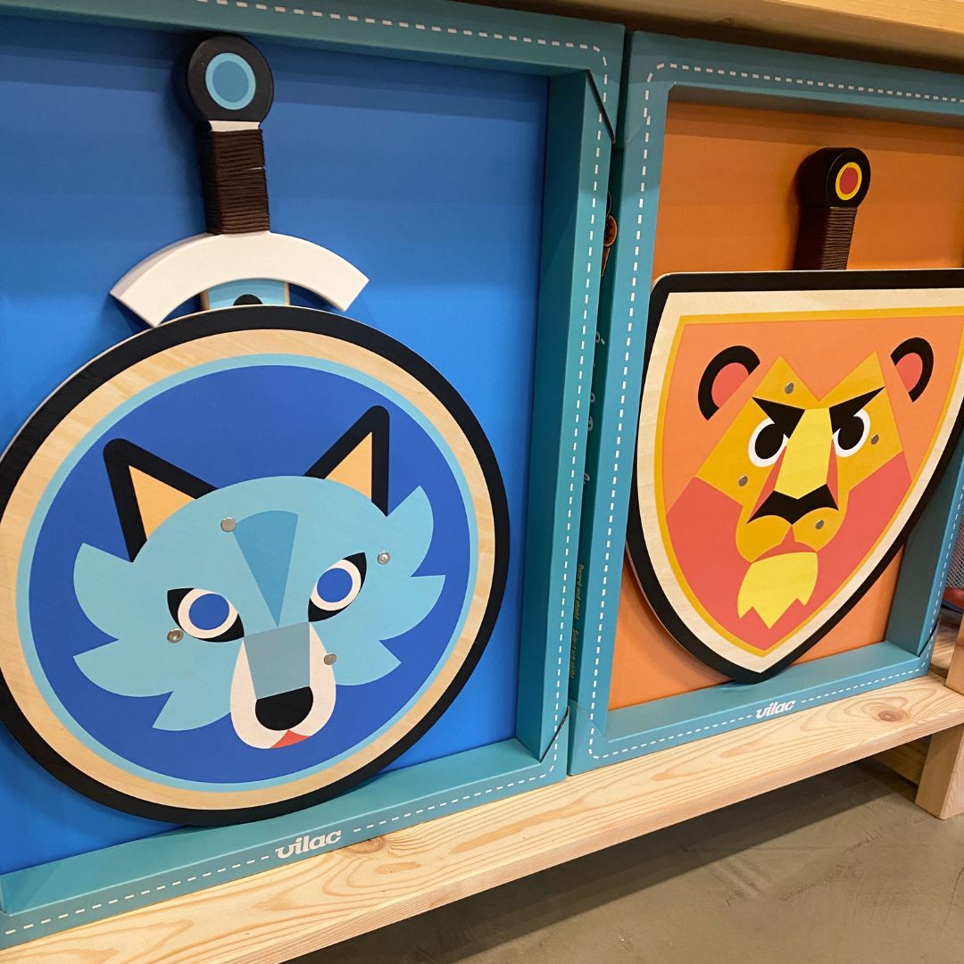 Sæt med blå skjold og sværd i træ med motiv af ulv, fra Vilac, set på hylde hos Nordic Simply