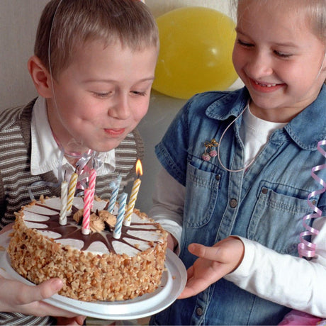 Dreng puster lys ud på lagkage til fødselsdag