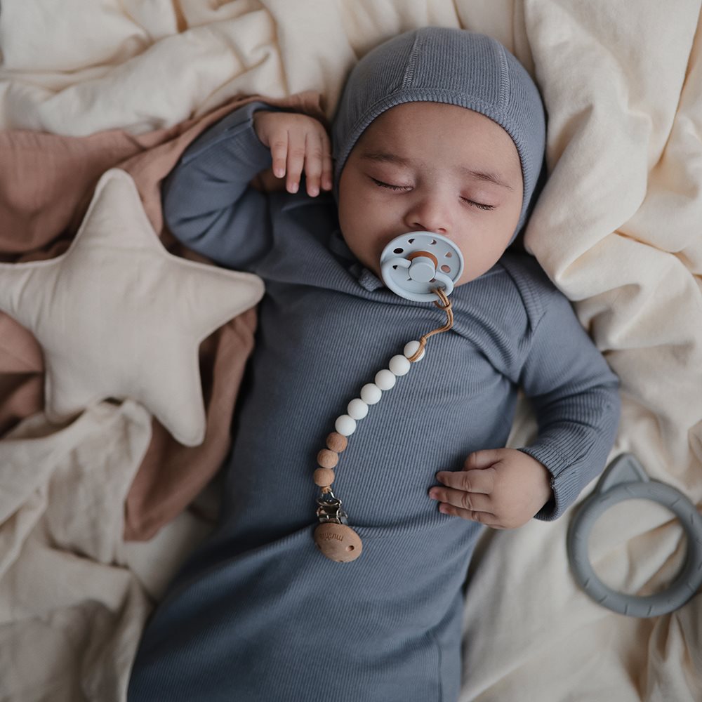 blå suttesnor med kugler i silikone, holder sutten på plads, fra Mushie, her set med baby.