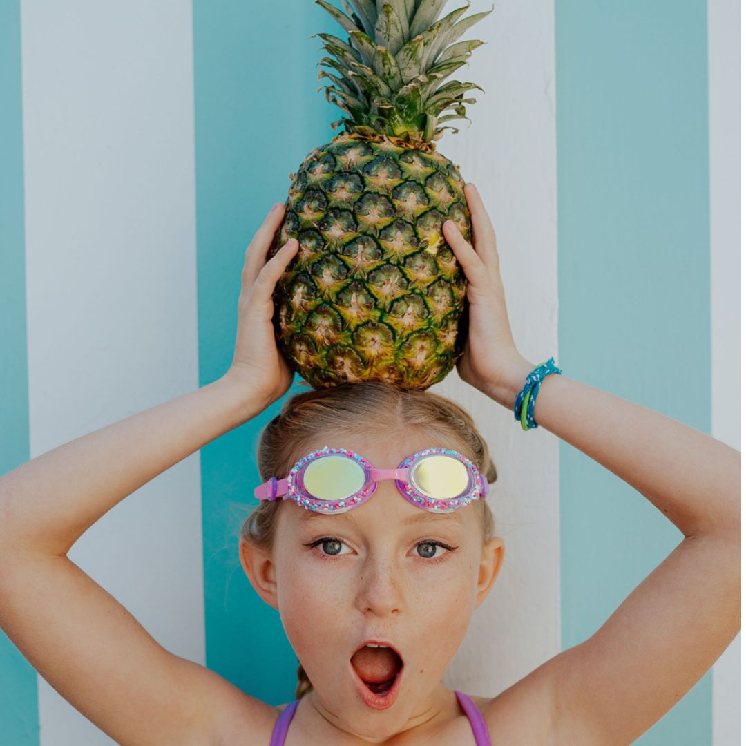 pige med ananas på hovedet og lilla svømmebriller dekoreret med krymmel og konfetti fra Bling20, i panden