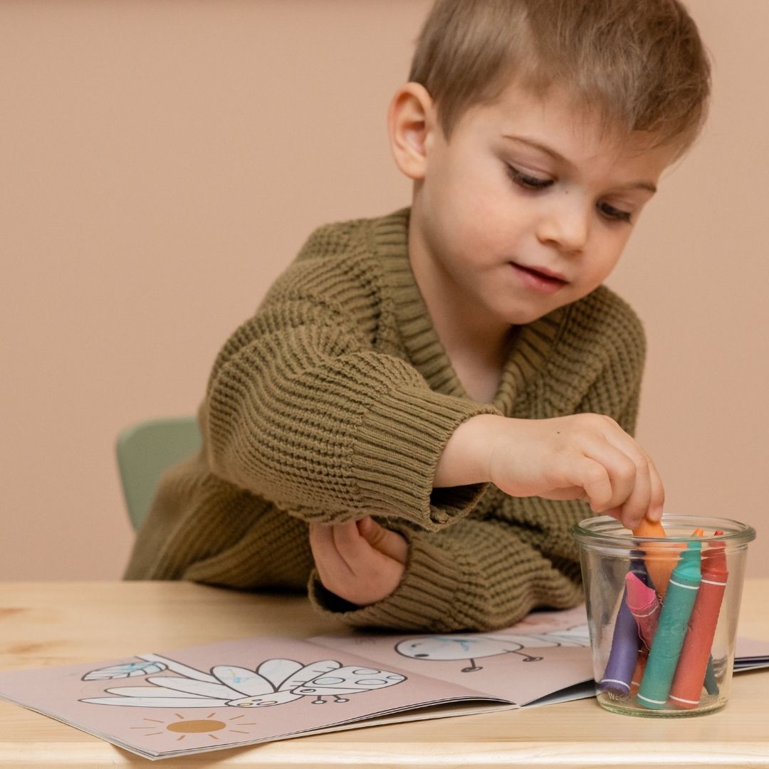 Dreng maler i tegnebog med voksfarver begge dele fra Little Dutch fås hos Nordic Simply