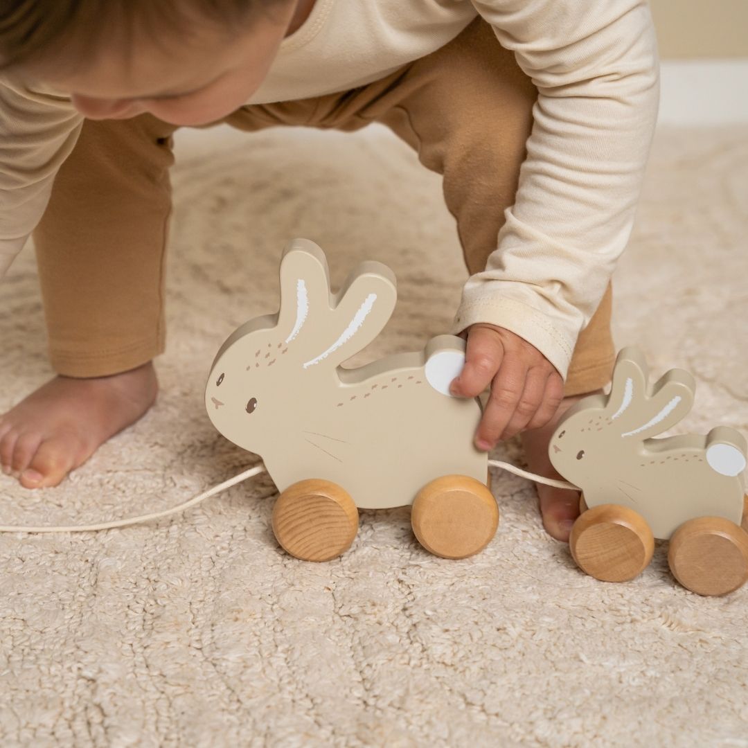 Barn leger med trække-kaniner i træ FSC, trækker de søde kaniner på hjul.