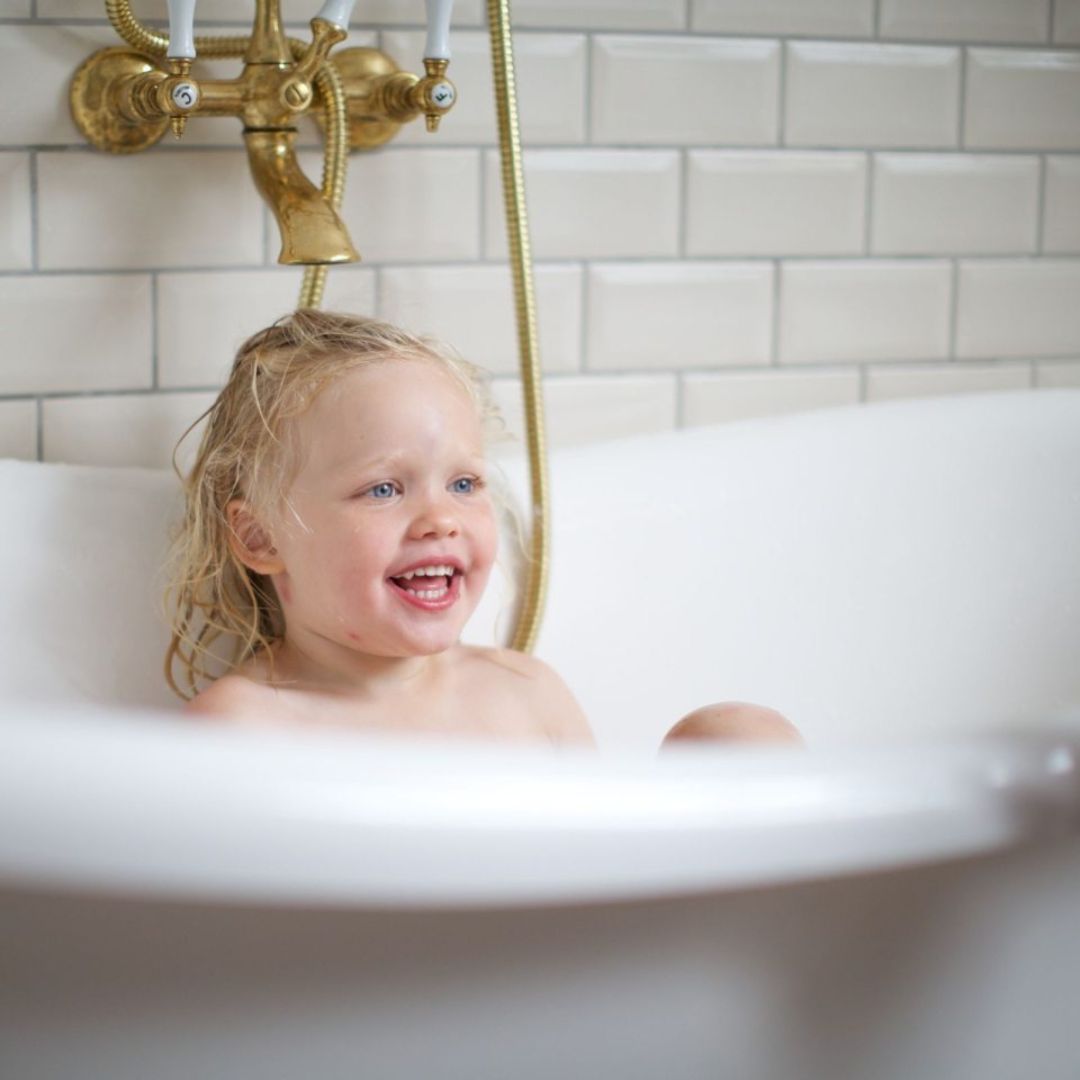 Pige ler i badekar med, sjove pingvin tryllekugler fra Tinti, der farver badevandet, fås hos Nordic Simply