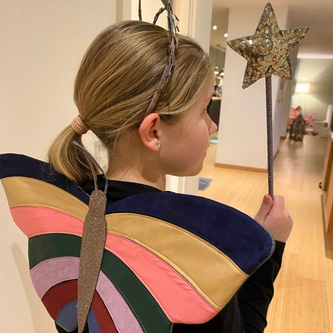 Pige set bagfra med sommerfuglevinger og tryllestav med guld-stjerne, fra Mimi & Lula fås hos Nordic Simply