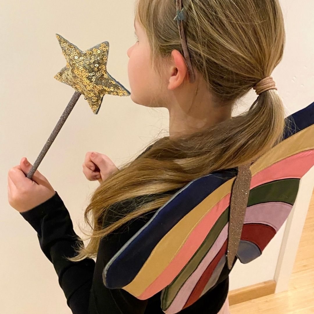 Pige set fra siden med sommerfuglevinger og tryllestav i hånden med guld-stjerne, fra Mimi & Lula fås hos Nordic Simply
