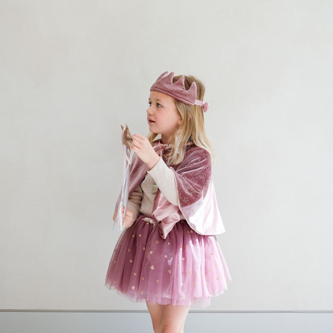 Pige med rosa krone, kappe og skørt og tryllestav med rosa stjerne med glitter på toppen, perfekt til rolleleg og tilbehør til udklædning, fra Mimi & Lula fås hos Nordic Simply