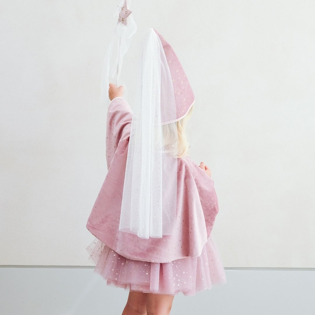 Pige set bagfra med høj rosa hat og kort rosa kappe holder tryllestav med rosa stjerne på toppen og hvidt slør, smuk udklædning til børn fra 3 år og op, fra Mimi & Lula fås hos Nordic Simply